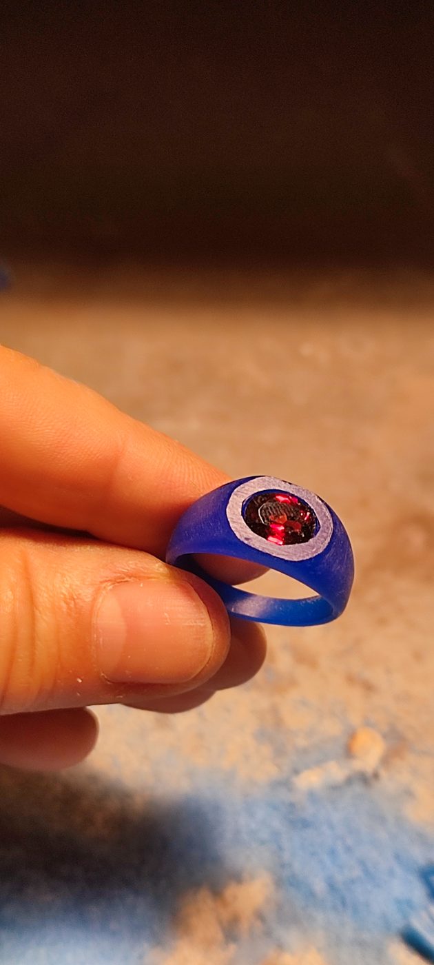 Un modello in cera blu con la pietra, in mano